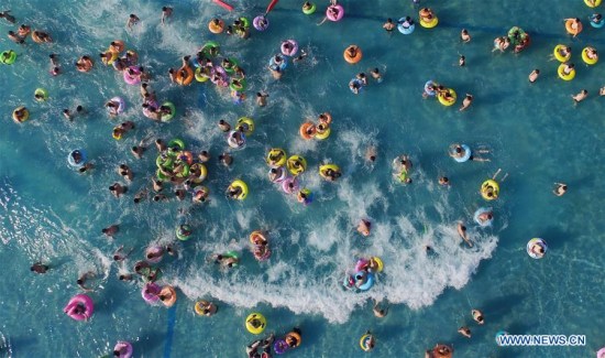 Tourists play in the water at a water park in Yangzhou City, east China's Jiangsu Province, July 11, 2017, escaping from the heat of summer. (Xinhua/Meng Delong)