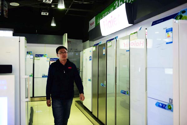 A consumer browses at refrigerators at a Haier store in Qingdao, Shandong province. (Photo by Yu Fangping/For China Daily)