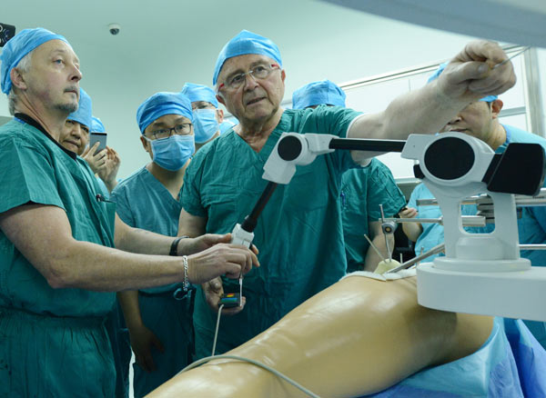 A doctor demonstrates how a robot conducts an orthopedic operation in Zhengzhou, Henan province. (Photo by Zhang Tao/For China Daily)