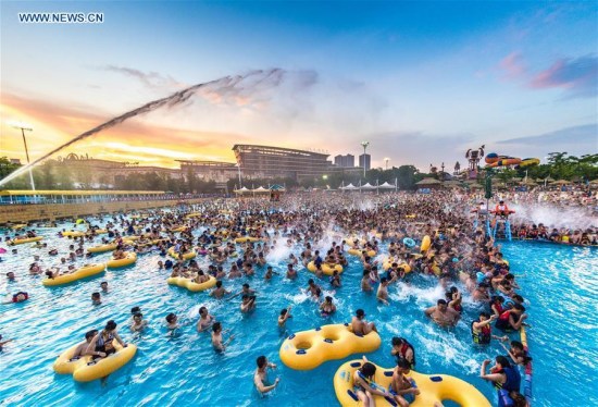 Tourists play in a water park in Wuhan, capital of central China's Hubei Province, July 15, 2017. Days of heat wave drove many citizens to the water park for fun and coolness. (Xinhua/Xiong Qi)