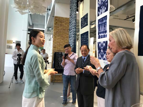 A student from Nanjing Normal University (left) presents tea art to guests in London, UK on July 17, 2017. (Photo/chinadaily.com.cn)
