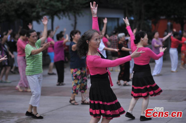 Middle-aged women enjoy their time of dancing with background music in their wireless headsets on a square in Chongqing municipality. (Photo/China News Service)