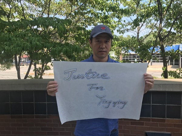A local resident holds a sign to show support to Zhang and her family outside the US district court in Urbana, Illinois on Thursday.ZHANG RUINAN / FOR China Daily
