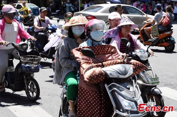 Motorcyclists use masks and hats to protect themselves from the sun's harsh rays in Fuzhou City, the capital of East Chinas Fujian Province, July 10, 2017. (Photo: China News Service/Liu Kegeng)