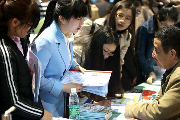 Graduates from normal universities in Hunan province interact with their potential employers at a job fair in Hengyang in March. (Peng Bin/For China Daily)