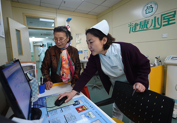 A patient is given her physical checkup results at a community medical service center in Beijing in April, after a comprehensive medical reform started in the capital.(Wang Xin/For China Daily)