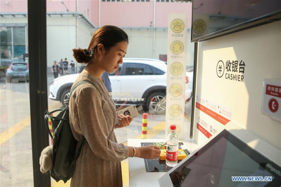 A customer gets ready for QR code payment at BingoBox, an unmanned store in east China's Shanghai, July 21, 2017. The 15-square meter store has no cashier, which accepts self-assisted payments by quick response (QR) codes. (Xinhua/Ding Ting)