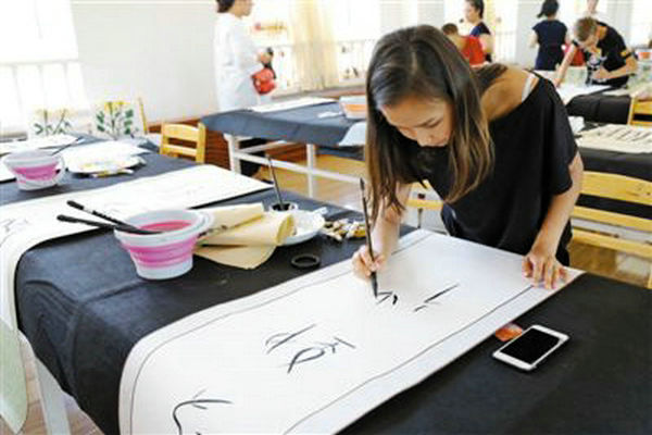 Anya, a 14-year-old student from Russia practices calligraphy while attending a Chinese culture summer camp in Heilongjiang province, China. (Photo/People's Daily)