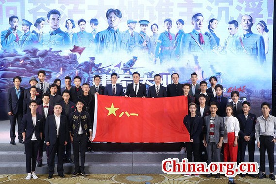 A star-studded cast pose with a Chinese army flag at the premiere in Beijing of the war epic The Founding of an Army, July 24, 2017. (Photo/ China.org.cn)