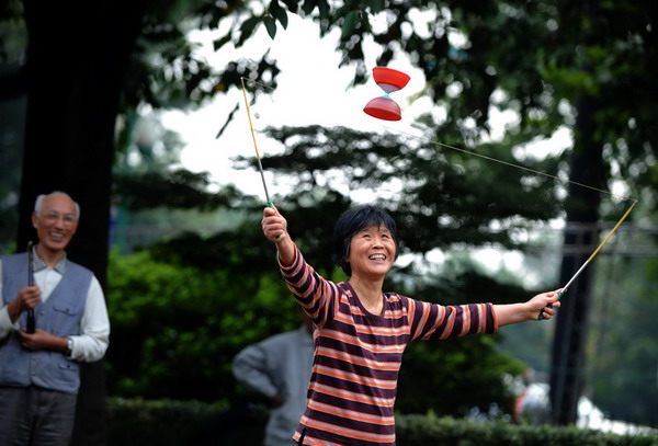 A senior citizen plays diabolo by the West Lake in Hangzhou, capital of East China's Zhejiang province, Oct 15, 2010. (Photo/Xinhua)