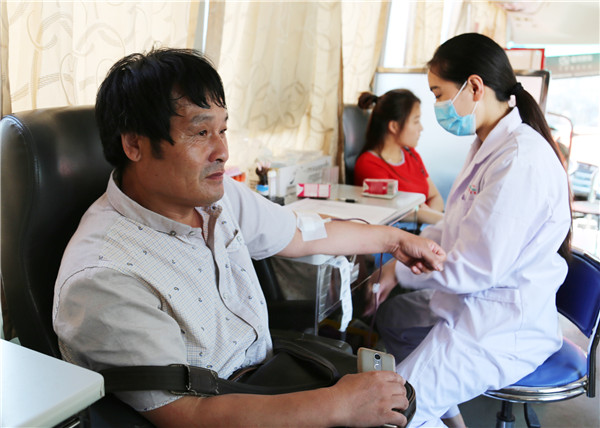Kong Guochang donates blood in Zhoukou city, Central China's Henan province.(Photo by Hu Hongtao for China Daily)
