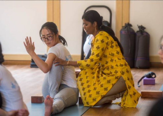 Indian yoga teacher Subbulakshmi Velusamy Rtrains a woman to learn yoga. (Photo/Xinhua)