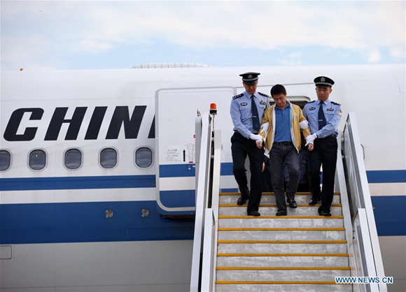 Ren Biao (C), disembarks from a plane under police escort at Beijing Capital International Airport in Beijing, capital of China, July 29, 2017. Ren Biao, one of China's most wanted fugitives, has returned to China and turned himself in to the police, the anti-corruption authority said Saturday. (Xinhua/Jin Liwang)