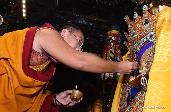 The 11th Panchen Lama Bainqen Erdini Qoigyijabu pays homage to the life-sized statue of Buddha Sakyamuni as a 12-year-old in Jokhang Temple, Lhasa, capital of southwest China's Tibet Autonomous Region, July 27, 2017. The Panchen Lama performed a series of Buddhist services in Lhasa over the past few days. (Xinhua/Chogo)