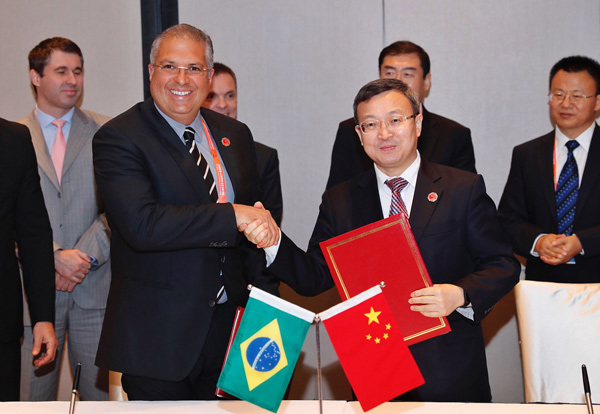 Vice-Minister of Commerce Wang Shouwen shakes hands with Marcelo Maia, secretary of commerce and services at Brazil's Ministry of Development, Industry and Foreign Trade, at the MOU signing ceremony in Shanghai on Tuesday. (CHINA NEWS SERVICE)