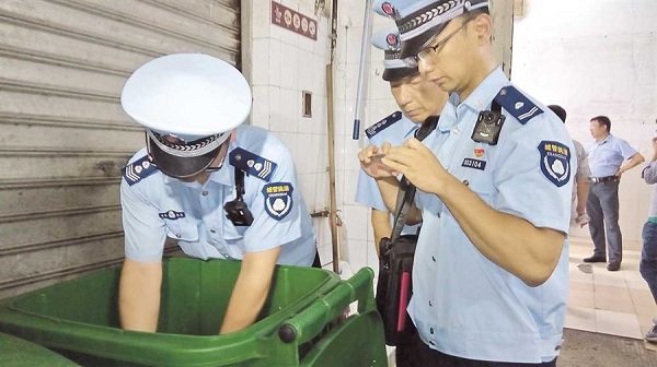 Civic inspectors check garbage bins at Landmark Department Store yesterday. (Chen Xihan)