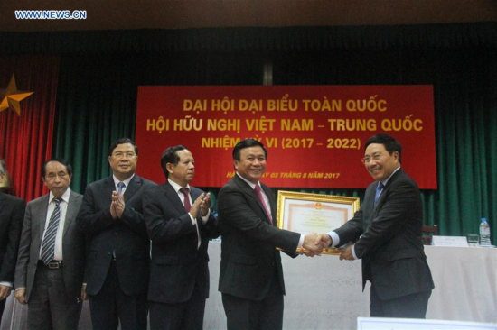 Vietnamese Deputy Prime Minister and Minister of Foreign Affairs Pham Binh Minh (1st R) shakes hands with President of the Vietnam-China Friendship Association Nguyen Xuan Thang (2nd R) in Hanoi, Vietnam, Aug. 3, 2017. (Xinhua/Le Yanna)