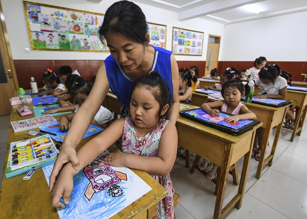 Students learn to paint at a tutorial class on Tuesday in Dachang Hui autonomous county in Hebei province. (LI XIAOGUO/XINHUA)