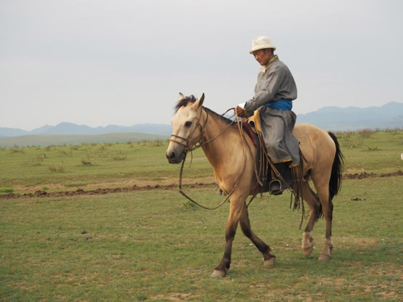 Mao Hoaer walks his horse in the grasslands.  Photo/CGTN