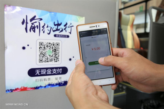 A passenger pays for bus ticket by quick response (QR) code in Beibei District, southwest China's Chongqing Municipality, Aug. 3, 2017. Mobile payments started operation in some bus lines in Chongqing. Passengers can pay for bus tickets by scanning QR codes. (Xinhua/Qin Tingfu)