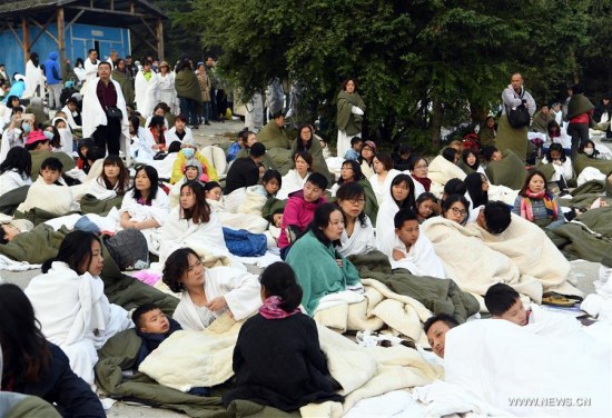 Tourists wait for rescue at the parking lot of the InterContinental Resort Jiuzhai Paradise in quake-hit Jiuzhaigou County, southwest China's Sichuan Province, Aug. 9, 2017. A 7.0-magnitude earthquake struck Jiuzhaigou Tuesday night. (Xinhua/Fan Peishen) 