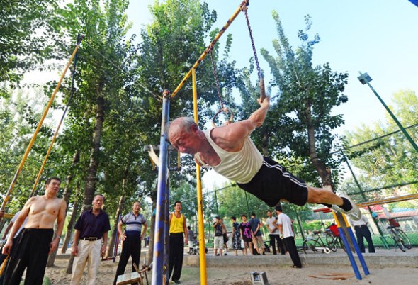 A 75-year-old man exercises on rings at a park in Tianjin on Tuesday, China's National Fitness Day.(Photo by SHI SONGYU/FOR CHINA DAILY)