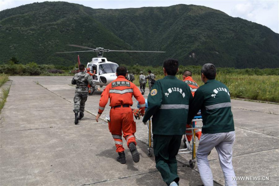 Injured people are transferred to a helicopter in Jiuzhaigou County, southwest China's Sichuan Province, Aug. 10, 2017. Medical treatment service is provided to aid the affected people after a 7.0 magnitude earthquake struck Jiuzhaigou County in Sichuan Province on Tuesday. (Xinhua/Fan Peishen)