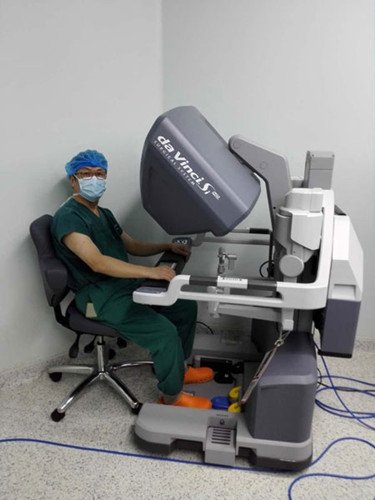 A surgeon sits before the control desk of a da Vinci robotic surgical system.Photo provided to chinadaily.com.cn