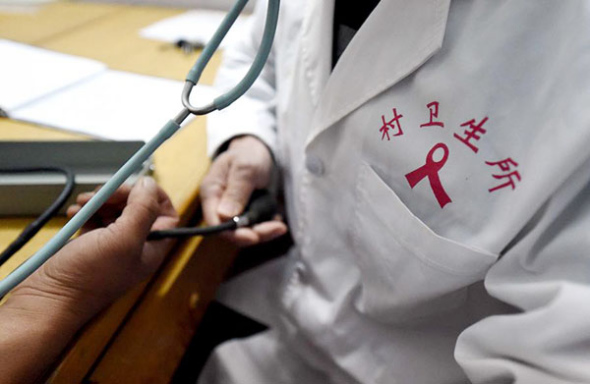 An HIV positive patient, not pictured, receives a blood pressure test in Weishi county, Central China's Henan province in this Nov 30, 2015 file photo. （Photo/Xinhua）