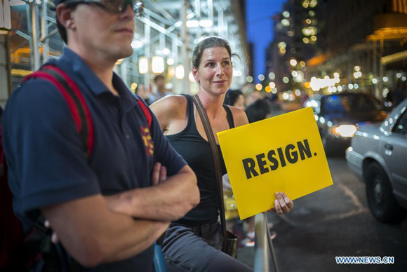 A woman holds a sign during a protest outside the Trump Tower in New York, the United States, Aug. 14, 2017. Thousands of protesters crowded the streets around Trump Tower before U.S. President Donald Trump's first visit to the building since taking office on Monday. (Xinhua/Li Muzi)