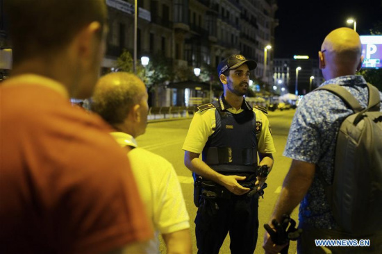 A security staff talks to pedestrians following a terrorist attack in central Barcelona, Spain, on Aug. 17, 2017. Thirteen people were confirmed dead and more than 100 others injured, with some of them in very serious condition in Barcelona terror attack on Thursday afternoon, a Spanish official said. (Xinhua/Han Chong)