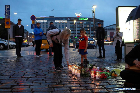 People mourn victims of the stabbing attacks in Turku, southwestern Finland, on Aug. 18, 2017. Several people were stabbed in downtown Turku, southwestern Finland on Friday, when more than one man mounted the attacks simultaneously. At least two died and eight others were injured, according to local media. (Xinhua/Zhang Xuan)