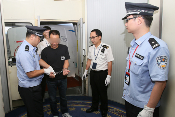 Ji Wenhong is detained on suspicion of smuggling luxuries at Xiamen Gaoqi International Airport in Fujian province on Wednesday. Ji was returned to China after Interpol captured him in Indonesia.