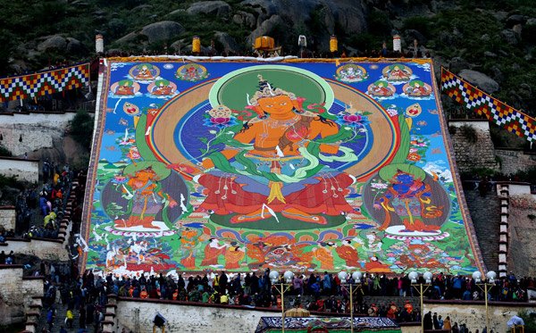 A painting of the Buddha, or a thangka, that is 37-by-40 meters, is placed on display at Drepung Monastery in Lhasa, the Tibet autonomous region, on Monday. (Photo by Feng Yongbin/China Daily)