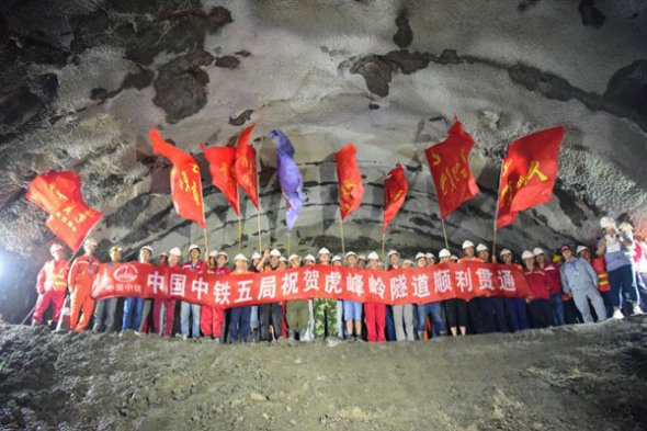 Workers celebrate the rocks on the final section were broken through in Hufengling Tunnel on Aug 20, 2017. (Photo provided to chinadaily.com.cn)