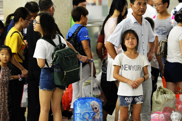 A girl tries not to cry at Hankou Railway Station in Wuhan, Hubei province, as she prepares to return home on Sunday. As summer vacation comes to an end, many children of migrant workers who traveled to big cities to spend time with their parents must say goodbye. (Photo by Jin Zhenqiang/China Daily)