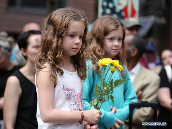 A girl holding a bunch of flowers participates in an evening vigil at Federal Plaza in Chicago, the United States, on Aug. 13, 2017. (Xinhua/Wang Ping)