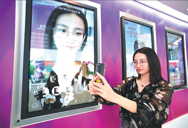 An employee of Meitu Co, Xiamen's largest high-tech enterprise, demonstrates a new mobile phone app that prettifies photos. Jiang Kehong / Xinhua