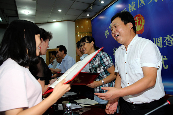 Selected mediators are awarded certificates by the Xincheng district court in Xi'an, Shaanxi province, last week. They will lighten the load of judges by handling domestic disputes.(Huo Yan/China Daily)