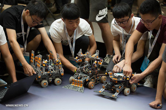Contestants debug robots during the World Robot Conference 2017 in Beijing, capital of China, Aug. 23, 2017. The five-day robot conference kicked off Wednesday with the theme Win-Win Collaborative Innovation Toward the Building of an Intelligent Society. (Xinhua/Jin Liwang)