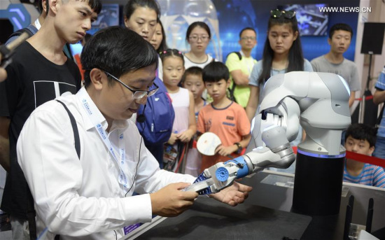 A visitor experiences a bionic arm installation during the World Robot Conference 2017 in Beijing, capital of China, Aug. 24, 2017. During the 5-day event, people came to Beijing Yichuang International Conference and Exhibition Center, experiencing the technology of robot and the possibility of future life. (Xinhua/Li Xin) 