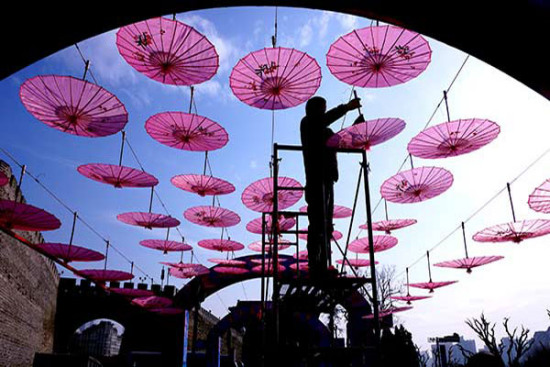 A worker hangs ornaments at the Ming Dynasty City Wall Ruins Park under a blue sky in Beijing in March, 2017. LIU PING/CHINA DAILY