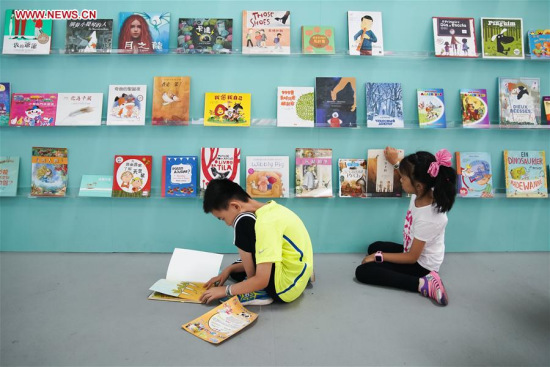 Children read books at picture books exhibition of the 24th Beijing International Book Fair, in which nearly 10,000 picture books of 14 languages were on display, in Beijing, capital of China, Aug.26, 2017. (Xinhua/Shen Bohan)
