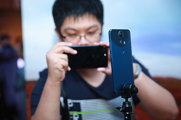 A man takes photos of Protruly's virtual reality-enabled smartphone. (Photo provided to chinadaily.com.cn)