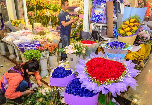 Flower shop sales assistants organize bouquets in Kunming, Yunnan province, on Friday, hoping for a boom in sales for the Qixi Festival.(Long Yudan for China Daily)