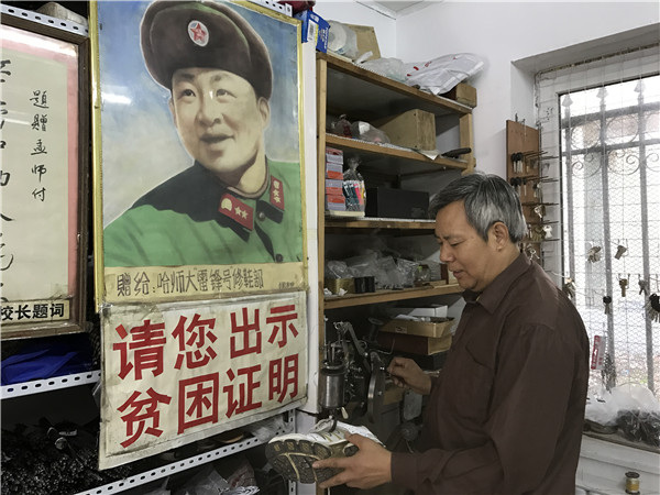 Guangbin operates his shoe-repairing machine in his workshop in Harbin, Northeast China's Heilongjiang province, Aug 28.(Photo by Zhou Huiying/chinadaily.com.cn)
