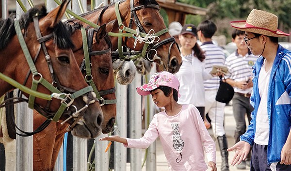 Children and their parents attend a promotion event at a horse racing club in Beijing. (Photo/Xinhua)