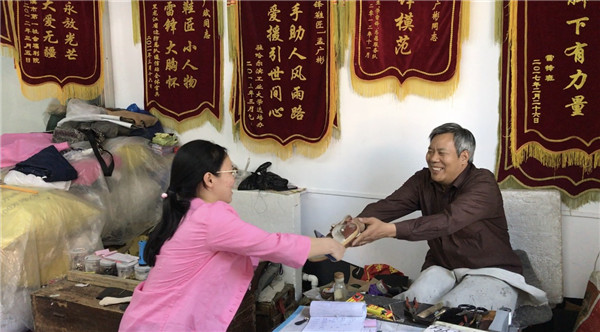 Meng Guangbinis mends a shoe in his workshop in Harbin, Northeast China's Heilongjiang province, Aug 28.(Photo by Zhou Huiying/chinadaily.com.cn)