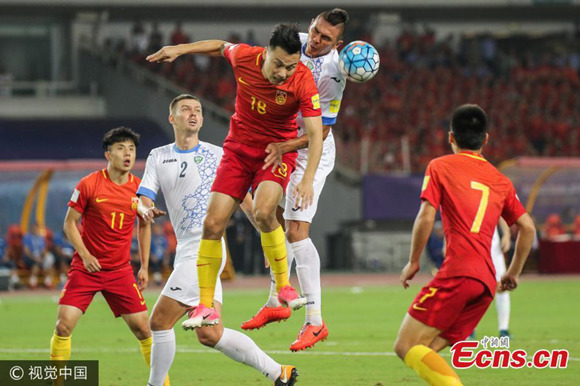 Players of China and Uzbekistan in action on Aug 31 in Wuhan, Hubei province. A late penalty kick from Gao Lin helped China keep the slim hope to enter the 2018 World Cup as Marcello Lippi's side beat Uzbekistan 1-0 at home on Thursday in the penultimate round of the Asian qualifying campaign. (Photo/VCG)