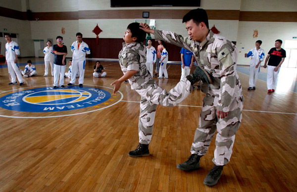 Young people learn self-defense during a course at a high school in Xi'an, Shaanxi province. (Photo:China Daily/Liang Meng)